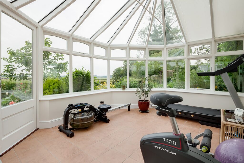 Harlton, Cambridgeshire, England - June 24 2019: Home conservatory gym with exercise machines.